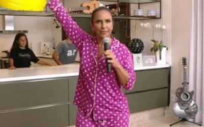cantora ivete sangalo cantando em sua sala vestindo um pijama rosa com bolinhas brancas