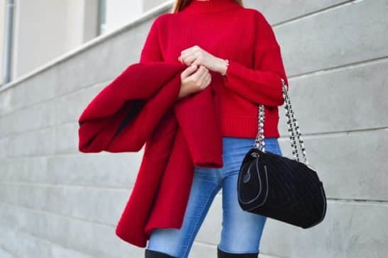 Look outono com sueter e casaco vermelho, calça jeans e bolsa preta