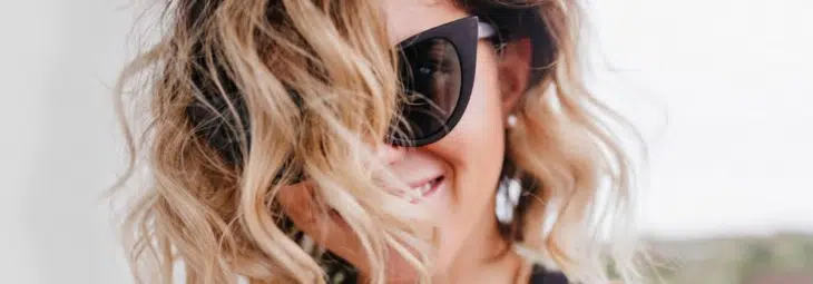mulher de óculos escuros e luzes nos cabelos