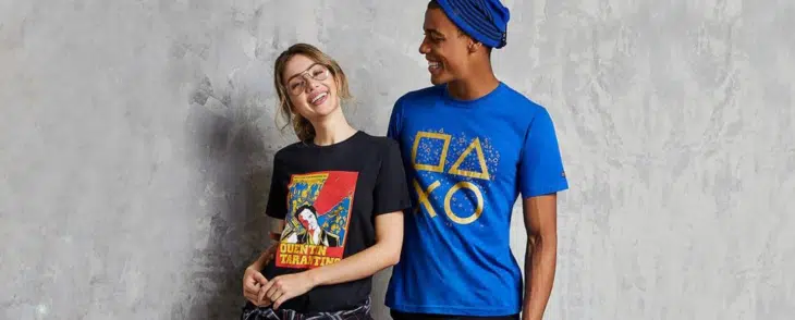 homem e mulher com roupas inspiradas em games e no mundo geek se abraçando em frente a um muro