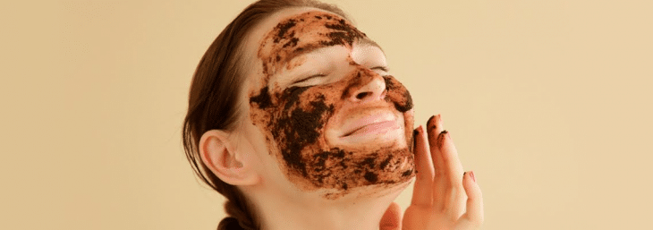 mulher sorrindo com máscara de café em seu rosto