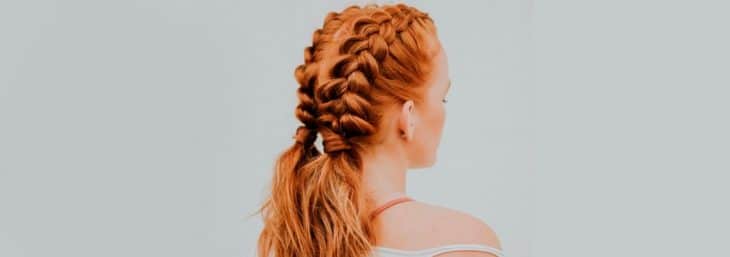 mulher ruiva de costas exibindo tranças dos dois lados da parte de trás da cabeça
