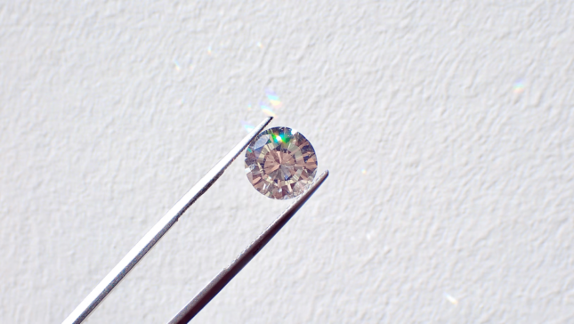 Mini pedra de diamante segurada com uma pinça
