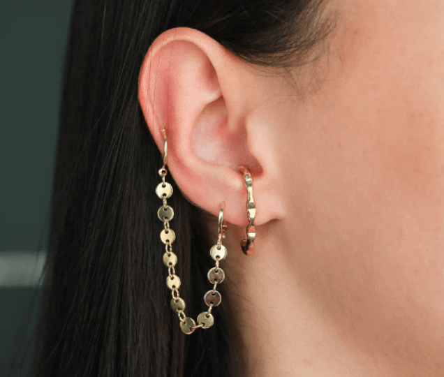 Mulher usa ear cuff folhada a ouro com argola