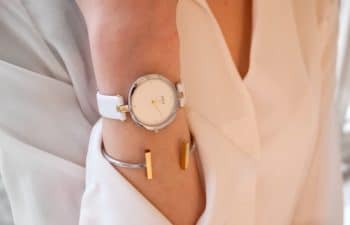 Mulher usa relógio e bracelete com camisa branca estilo Meghan Markle