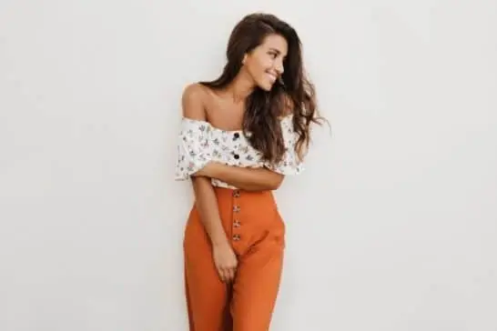 Mulher usa calça laranja com top floral