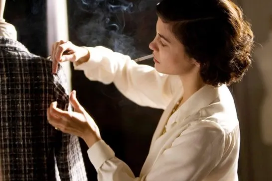 imagem do filme coco antes de chanel com mulher fumando um cigarro e prendendo partes de uma roupa