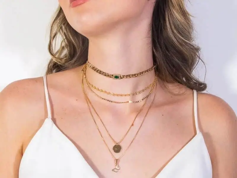 mulher com mix de colares e choker no pescoço