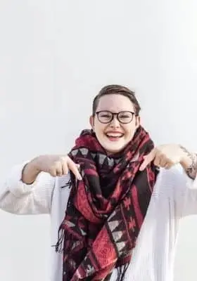 pessoa de óculos, sorrindo e com um cachecol