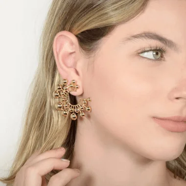 Máxi brinco dourado em mulher loira de olhos claros